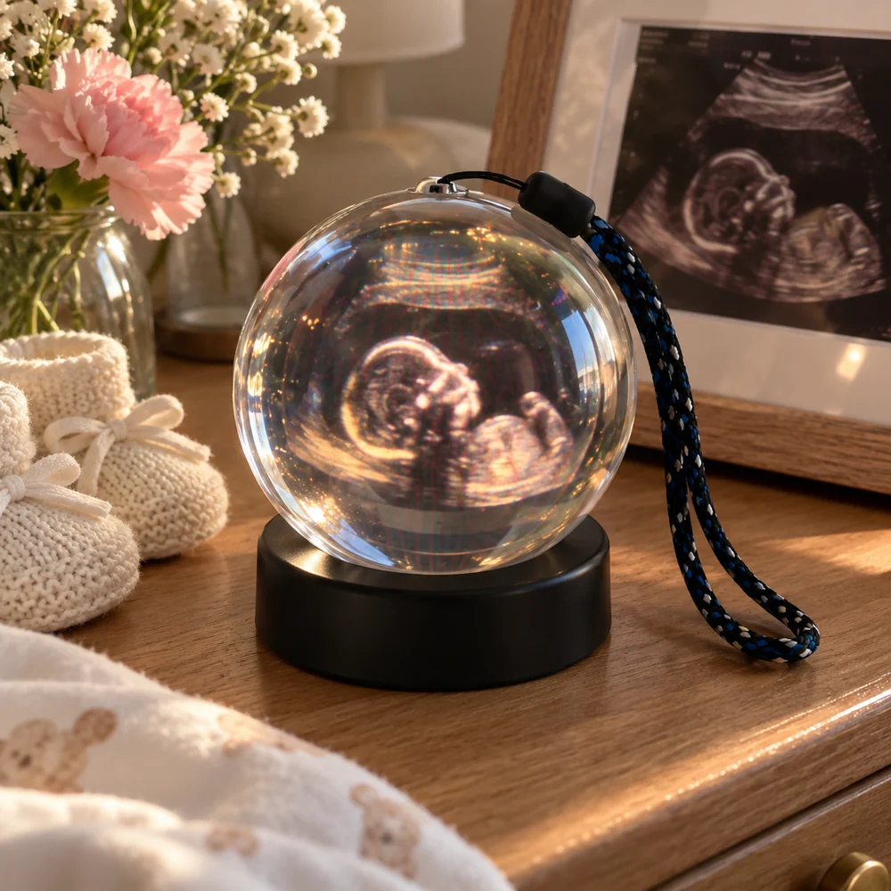 Ultrasound image on a sphere display beside flowers and baby clothes